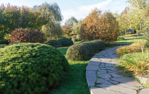 Cottage jardín con césped verde, árboles y arbustos recortados . — Foto de Stock