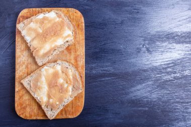 bl karşı ahşap bir mutfak tahtası üzerinde pollock karaca ile sandviç