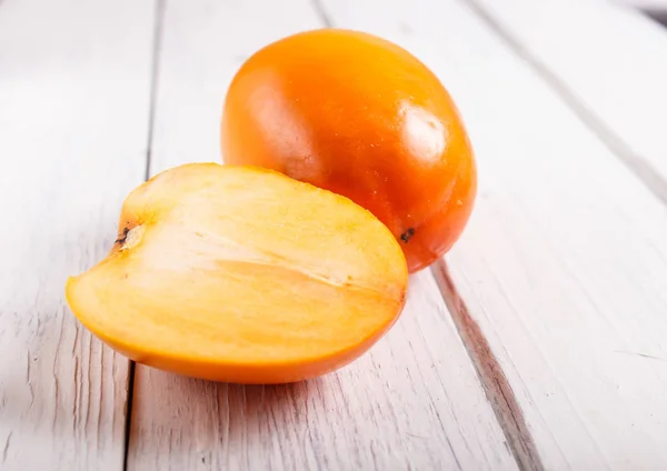 Reife orange Persimmon auf weißem Holzhintergrund — Stockfoto