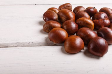 beyaz ahşap arka plan üzerinde tatlı kestane yığını
