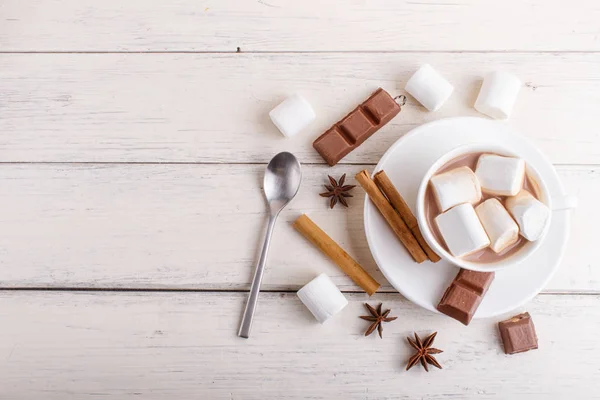 Una tazza di cioccolata calda con marshmallow e spezie su legno bianco — Foto Stock