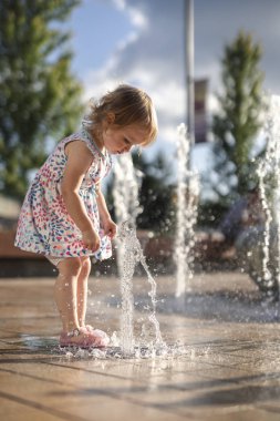 Renkli Elbise splash Çeşme ile oynarken Küçük Kız