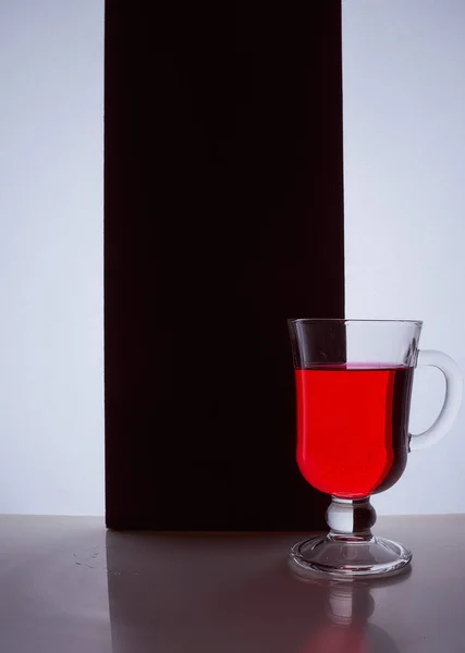 red glass with red liquid on a black white background. Stylish photo. Hight quality photo