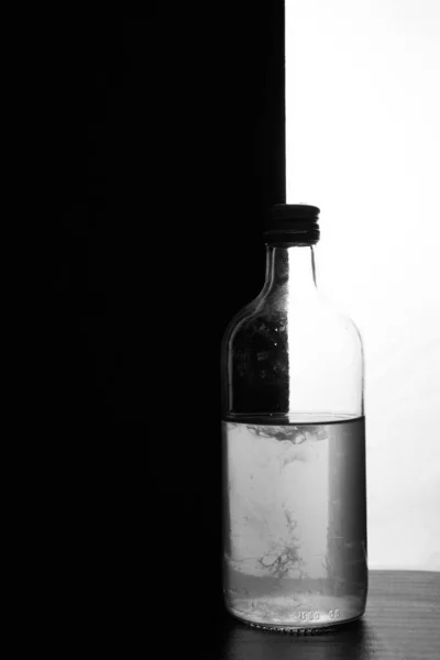 Una Pequeña Botella Sobre Fondo Blanco Negro Mitad Negro Mitad —  Fotos de Stock