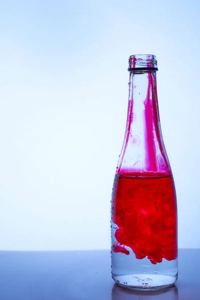 Tinta Roja Mezclada Con Agua Una Botella Vidrio Sobre Fondo —  Fotos de Stock