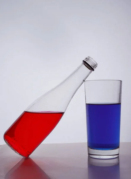 Composición Una Botella Vasos Con Líquido Multicolor Sobre Fondo Blanco —  Fotos de Stock