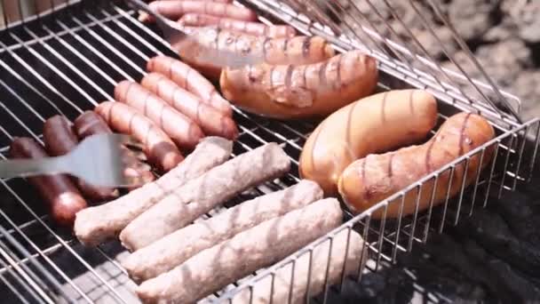 Párky a cevapcici smažené maso grilované na železném roštu . — Stock video
