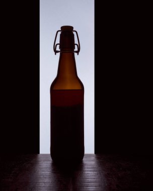 Siyah beyaz arka planda tıpası olan bir bira şişesinin renkli silueti.