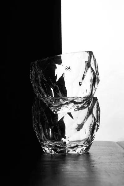 Склянки віскі лежать один над одним. Це пляшка віскі. Чорно-білий фон. Силуети — стокове фото
