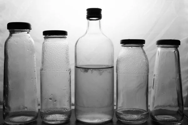 Samenstelling van glazen flessen op een lichte ondergrond — Stockfoto