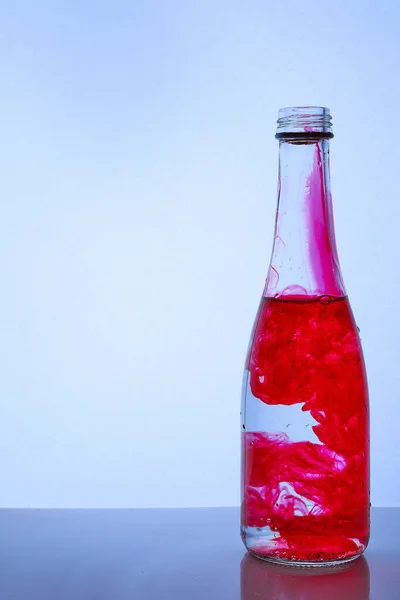 Tinta Roja Mezclada Con Agua Una Botella Vidrio Sobre Fondo —  Fotos de Stock