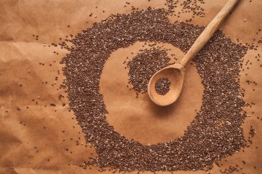 Çember şeklinde chia tohumları kahverengi arka planda duran tahta kaşıklar. Yüksek kalite fotoğraf