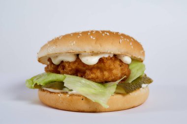 Soğan halkalı sulu burger, biber, salatalık, salatalık, salata, beyaz arka planda peynir. Yüksek kalite fotoğraf