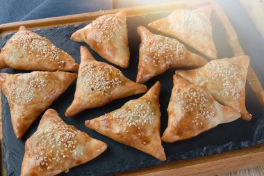 Özbek yemeği - taş bir levha üzerinde susam tohumlu mini samosa. Işık efektleri. Yüksek kalite fotoğraf