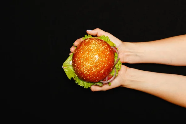 Hand Meisje Houdt Hamburger Broodje Tegen Zwarte Achtergrond Hoge Kwaliteit — Stockfoto