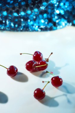 Beyaz arka planda mavi röfleli ve gölgeli bir kiraz. Yakın plan. Üst manzara, yüksek kalite fotoğraf.