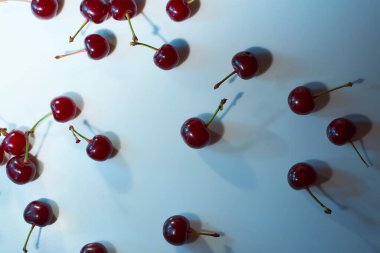 Beyaz arka planda mavi röfleli ve gölgeli bir kiraz. Yakın plan. Üst manzara, yüksek kalite fotoğraf.