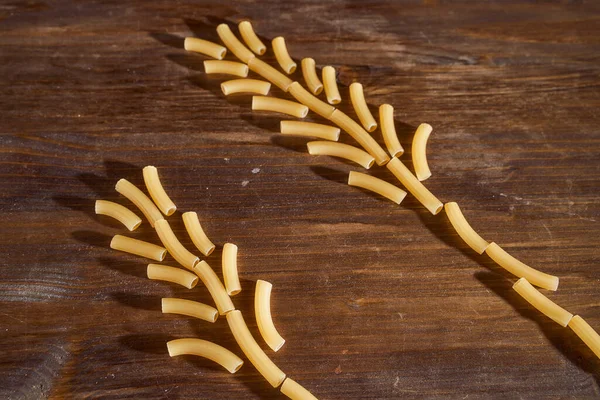 Gelbe Nudeln Form Von Weizenspitzen Liegen Auf Einem Braunen Tisch — Stockfoto