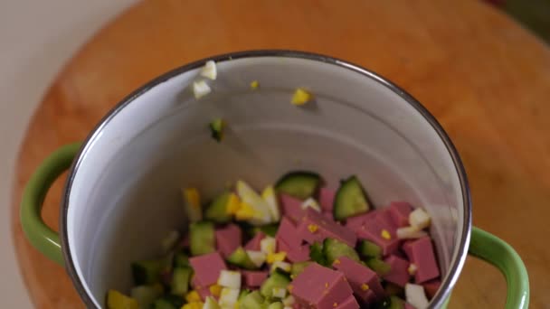 Mazăre verde sunt turnate într-un castron în care ingredientele pentru salata olivier, firimituri — Videoclip de stoc