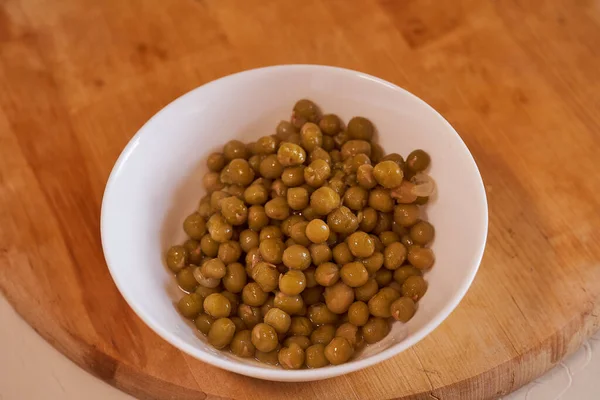 Witte Plaat Met Ingeblikte Groene Erwten Een Houten Ondergrond Hoge — Stockfoto