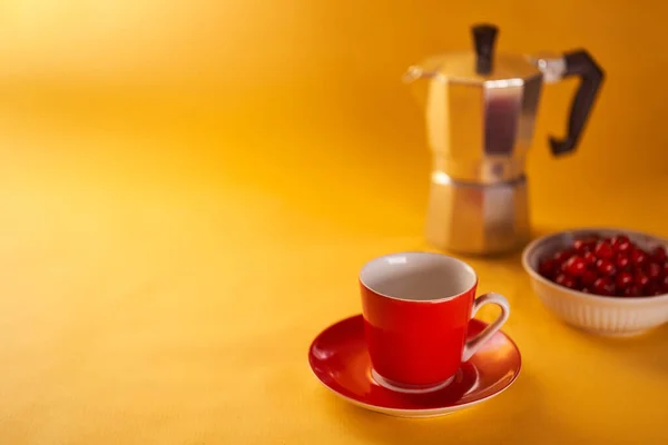 Une tasse de café rouge et un café geyser sur fond jaune. Avec espace de copie. — Photo