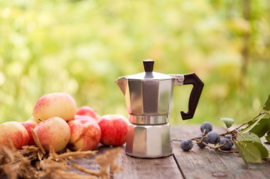 Gayzer kahve makinesi, yeşil bulanık arka plana karşı tahta bir tahtanın üzerinde duruyor. Kopyalama alanı olan. Yüksek kalite fotoğraf