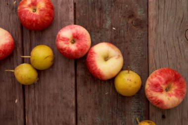 Kırmızı elmalar ve küçük armut tahta bir tahtanın üzerinde yatıyor. En iyi görüntü. Kopya alanı da var. Yüksek kalite fotoğraf