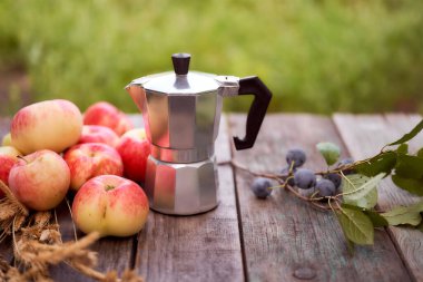 Gayzer kahve makinesi, yeşil bulanık arka plana karşı tahta bir tahtanın üzerinde duruyor. Kopyalama alanı olan. Yüksek kalite fotoğraf