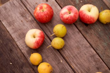 Kırmızı elmalar ve küçük armut tahta bir tahtanın üzerinde yatıyor. En iyi görüntü. Kopya alanı da var. Yüksek kalite fotoğraf
