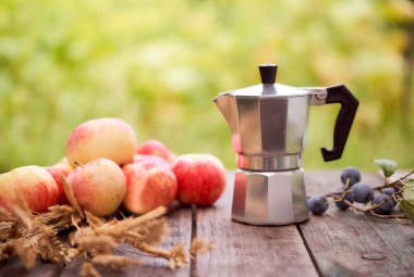 Gayzer kahve makinesi, yeşil bulanık arka plana karşı tahta bir tahtanın üzerinde duruyor. Kopyalama alanı olan. Yüksek kalite fotoğraf