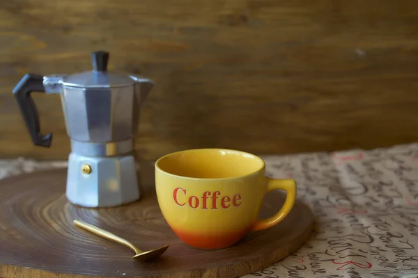 Geyser coffee maker on a wooden tray. Theres a cup of coffee next to it. Dark background — Stock Photo, Image