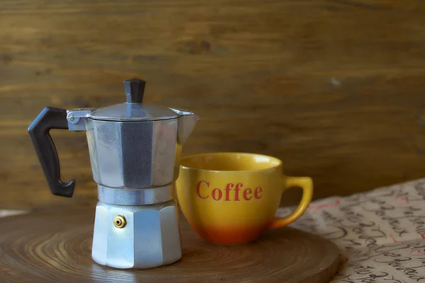 Geyser coffee maker on a wooden tray. Theres a cup of coffee next to it. Dark background — Stock Photo, Image