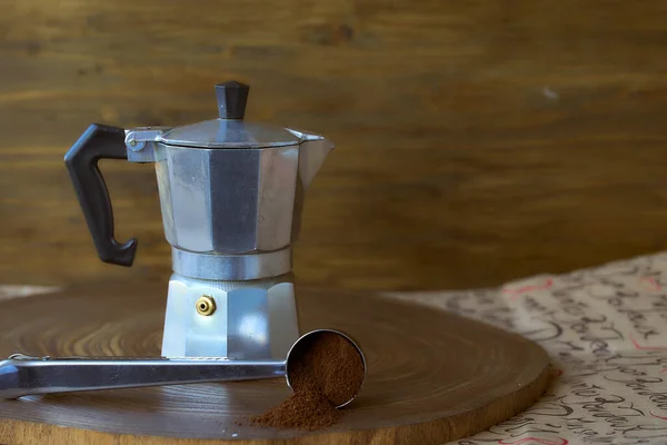 Geyser coffee maker on a wooden tray. With coffee spoon. Dark background — Stock Photo, Image