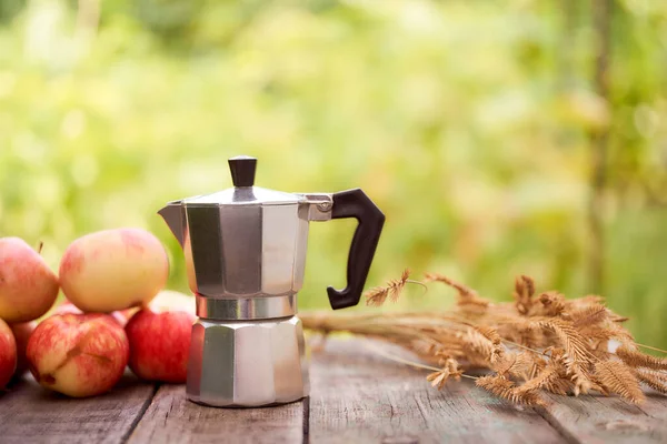 Gayzer kahve makinesi, yeşil bulanık arka plana karşı tahta bir tahtanın üzerinde duruyor. Kopyalama alanı olan. Yüksek kalite fotoğraf