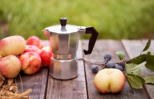 Gayzer kahve makinesi, yeşil bulanık arka plana karşı tahta bir tahtanın üzerinde duruyor. Kopyalama alanı olan. Yüksek kalite fotoğraf