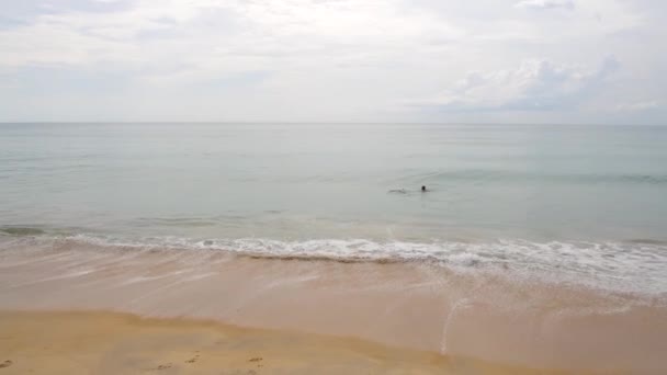 Giovane donna nuotare nel mare verde blu vicino alla costa con sabbia gialla — Video Stock