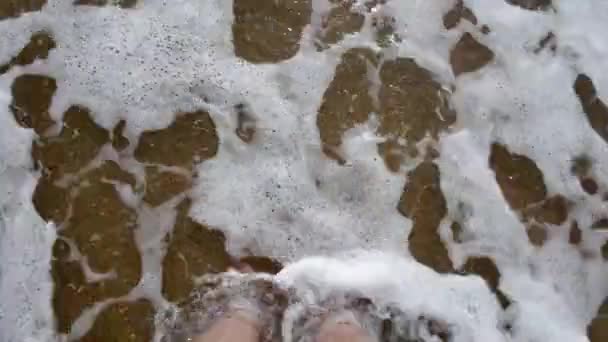 Point de vue de la jeune femme marchant sur la plage de sable doré à la mer. Jambes féminines marchant près de l'océan. Pied nu de fille allant sur le rivage sablonneux avec des vagues. Vacances d'été ou vacances Gros plan — Video