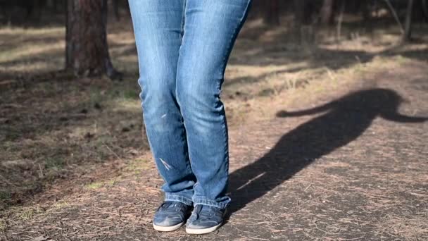 Mujer de fitness saltando cuerda. La hembra está trotando en la luz del día soleado en el fondo de los árboles de otoño, entrenando a las niñas al aire libre en el día de otoño, de cerca, en cámara lenta — Vídeo de stock