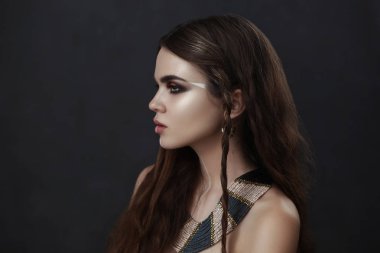 Güzel model yaratıcı makyaj ile derin duygusal olarak karanlık bir stüdyoda poz