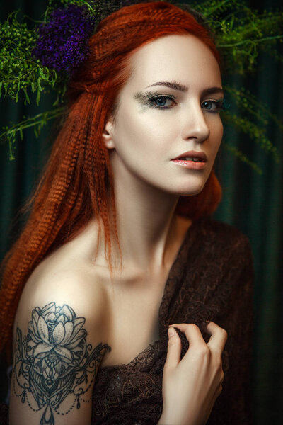 Young redhead model is posing with a creative makeup