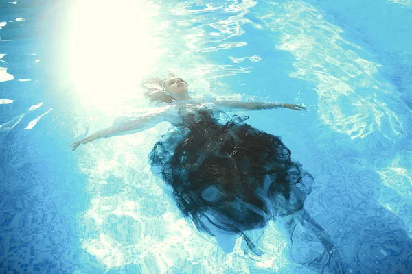 Beautiful model is posing in a swimming pool