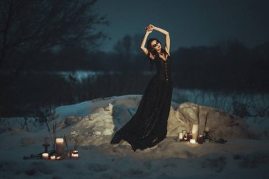  Güzel model siyah elbise giyen bir kar üzerinde poz