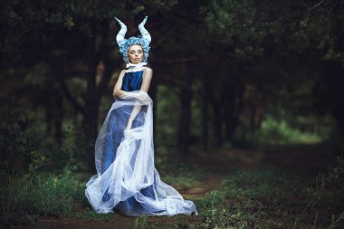 Güzel model mavi boynuzları olan bir ormandaki poz