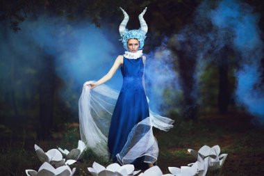 Güzel model mavi boynuzları olan bir ormandaki poz