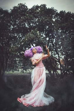 Güzel model pembe elbise yaratıcı bir perukla poz 