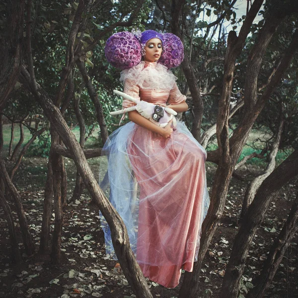 Beautiful model wearing pink dress is posing in a creative wig