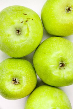 Yeşil elma beyaz bir arka plan üzerinde yalan söylüyor