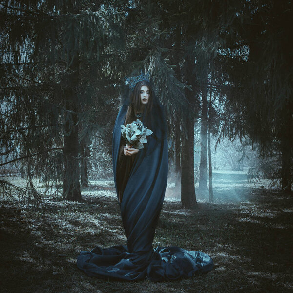 Красивая модель позирует в лесу с голубой тканью
