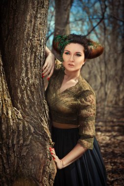 Model is posing in a spring forest as a Faun clipart
