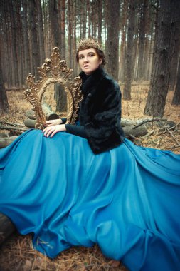 Mavi etek giyen modeli bir kraliçe gibi poz